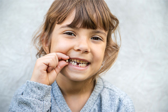 Niña con dientes podridos